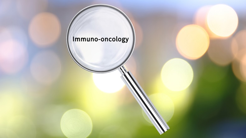 Magnifying lens over background with text Immuno-oncology, with the blurred lights visible in the background. 3D rendering.